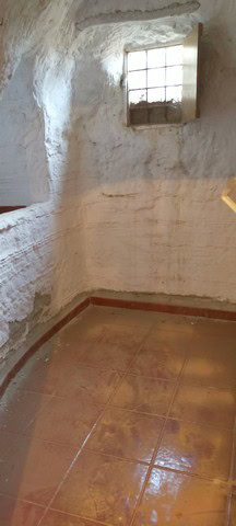 Interior view of a rustic village property with whitewashed walls and a small window in Benamaurel,.