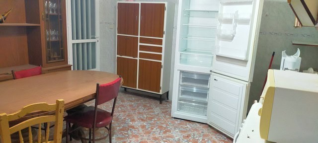 Spacious interior of a village property in Benamaurel, Granada, featuring a dining area and storage.