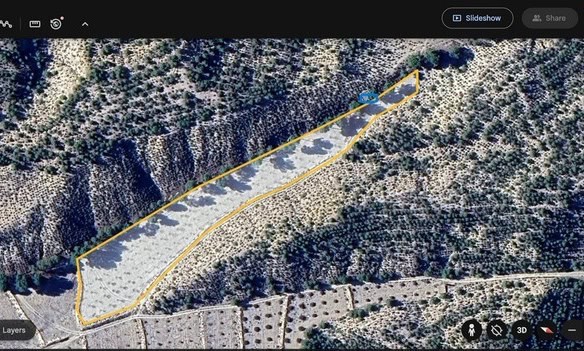 Aerial view of land plot in Benamaurel, Granada, with natural terrain and surrounding vegetation.