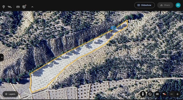 Aerial view of land plot in Benamaurel, Granada, with natural terrain and surrounding vegetation.