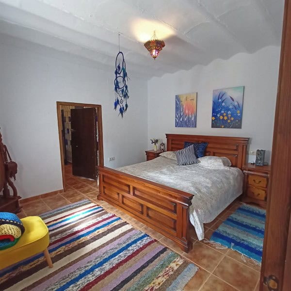 Charming bedroom in a village property in Hinojares, Jaen, featuring wooden furniture and colorful d.