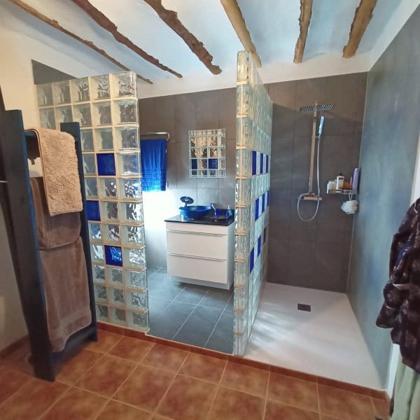 Charming village property with a modern bathroom in Hinojares, Jaen, featuring glass block walls and.