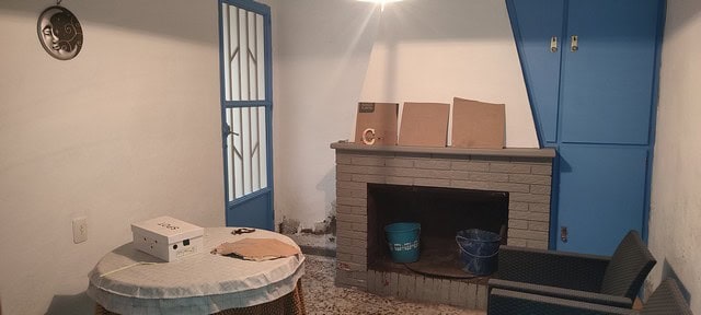 Charming town house interior in Tijola, Almeria with fireplace and blue storage cabinets.