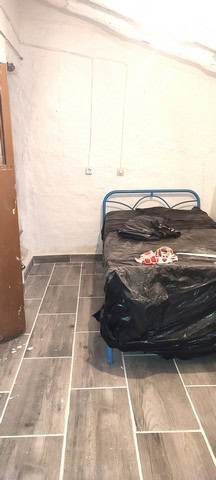 Charming town house interior in Tijola, Almeria with a simple bedroom setup and tiled flooring.