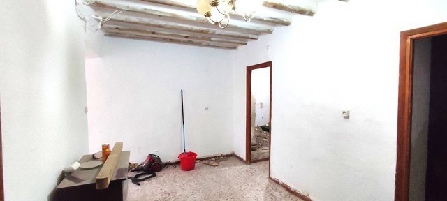 Interior view of a traditional town house in Tijola, Almeria, showing rustic ceiling beams and simpl.