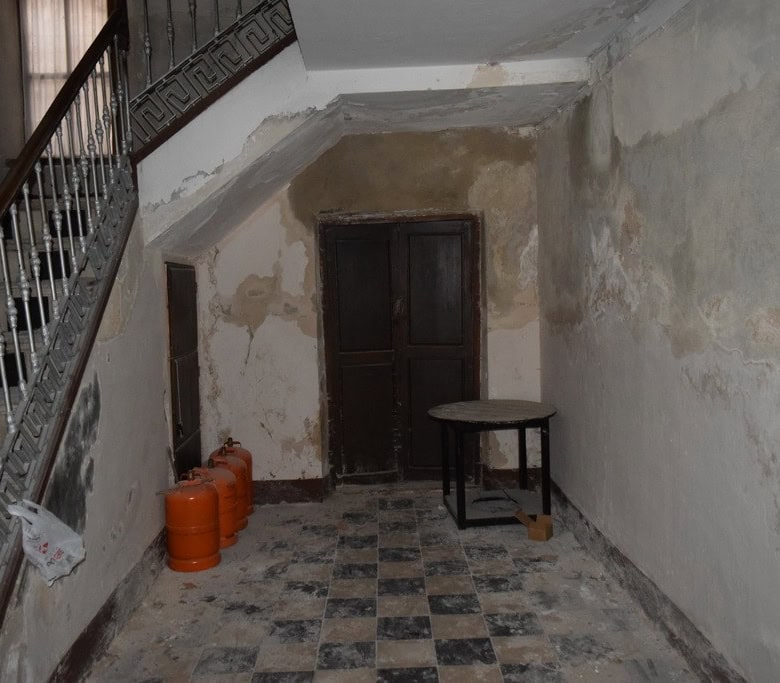 Interior of a rustic town house in Baza, Granada with worn walls and old flooring.