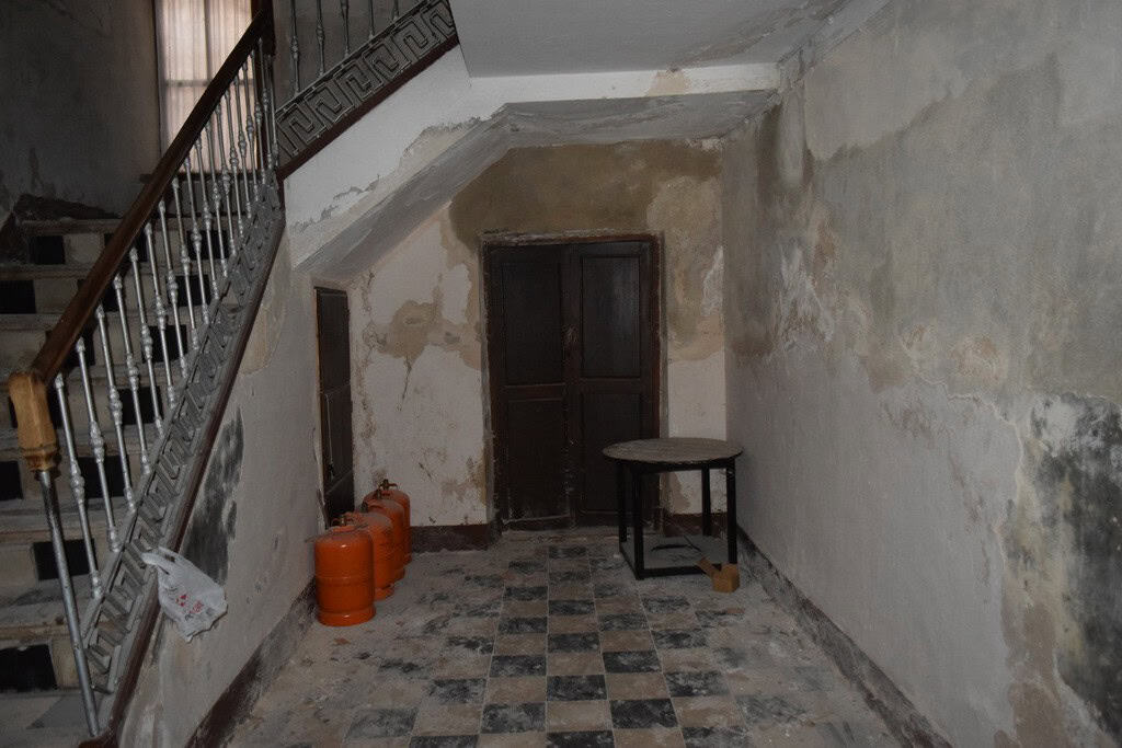 Interior of a rustic town house in Baza, Granada with worn walls and old flooring.