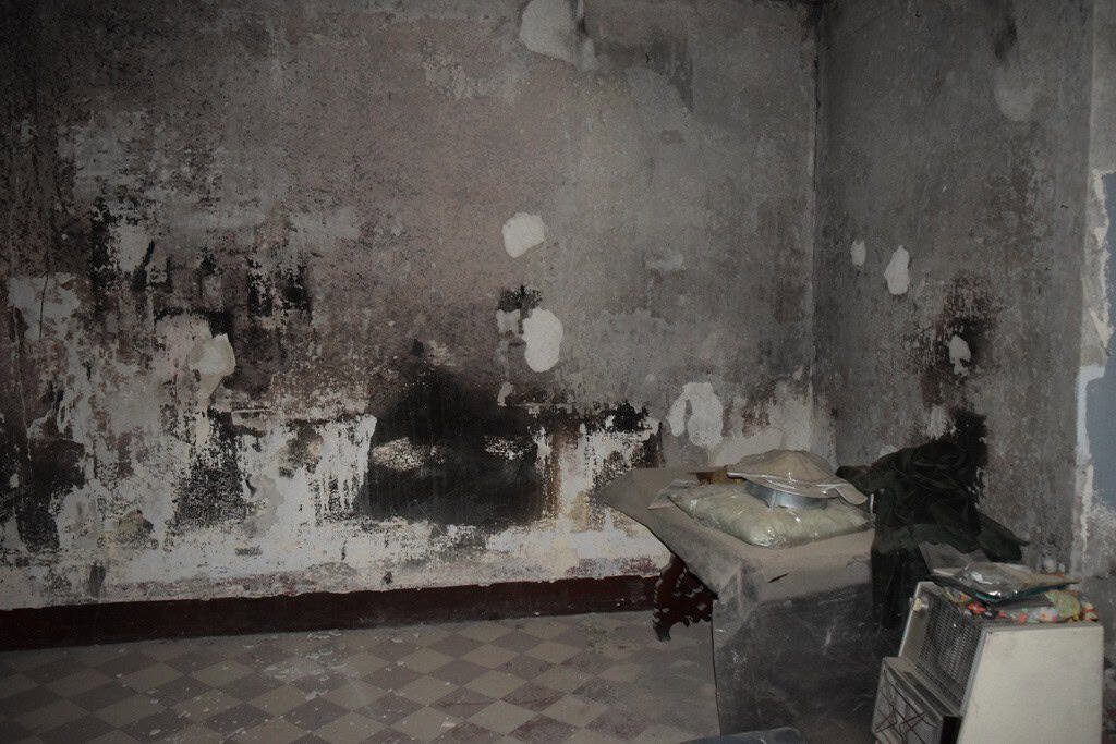 Abandoned interior of a town house in Baza, Granada with damaged walls and old furnishings.