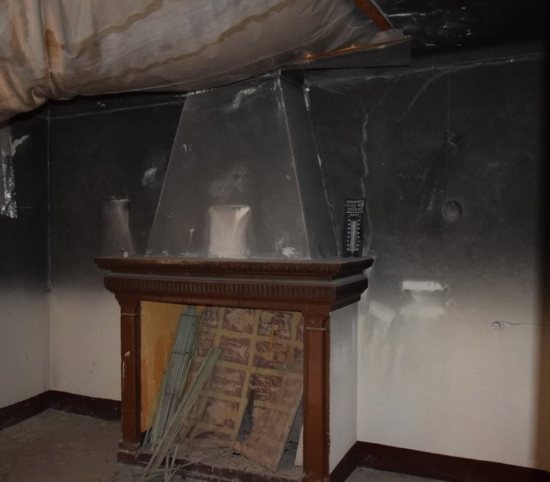 Fireplace in a town house in Baza, Granada, showing a traditional wooden mantel and a modern chimney.
