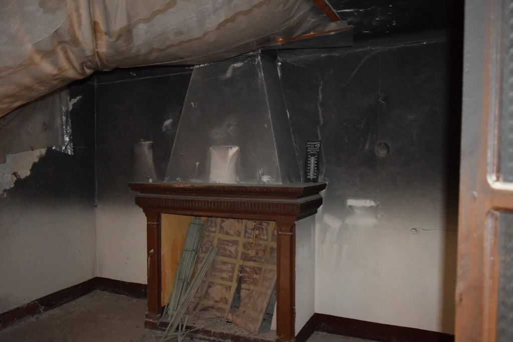 Fireplace in a town house in Baza, Granada, showing a traditional wooden mantel and a modern chimney.