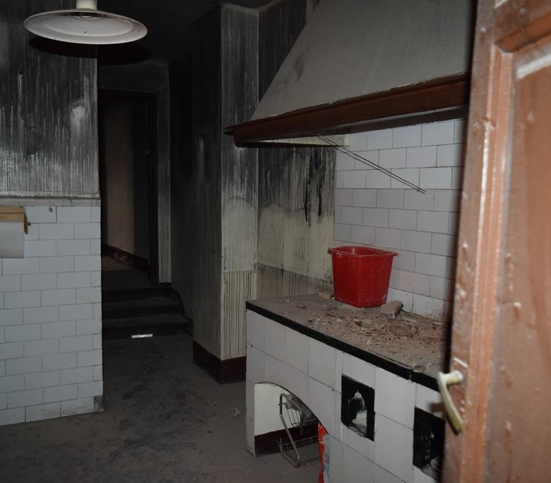 Interior of a town house kitchen in Baza, Granada, showing damaged walls and outdated appliances.
