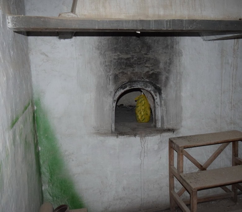 Traditional town house interior in Baza, Granada, with rustic walls and a small arched window.