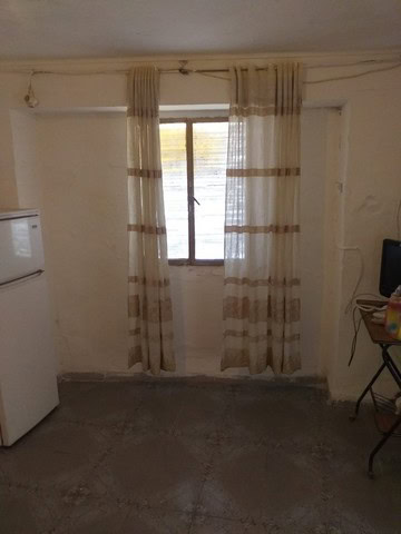 Cozy interior with window and curtains in a village property in Galera, Granada.