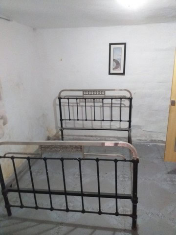Vintage metal bed frames in a rustic room in Galera, Granada.