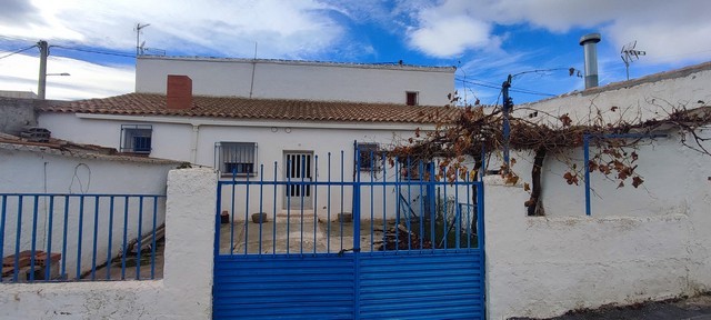 Village property with white walls and a blue gate in Seron, Almeria. Traditional rural home with out.