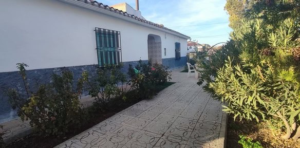 Charming rural property in Cortes de Baza, Granada, featuring a whitewashed exterior and lush garden.