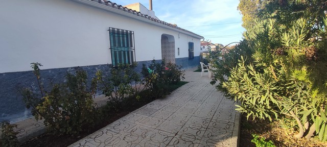 Charming rural property in Cortes de Baza, Granada, featuring a whitewashed exterior and lush garden.