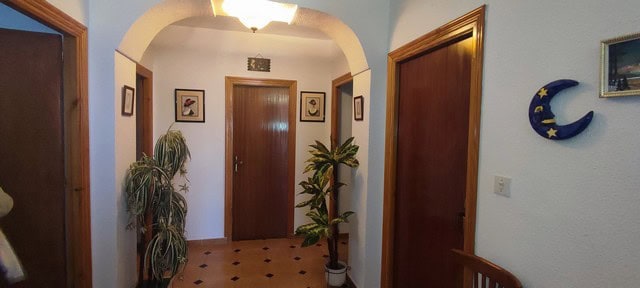 Charming rural home entrance in Cortes de Baza, Granada with potted plants and decorative moon wall.