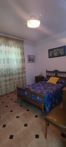Cozy bedroom with wooden furniture and colorful bedding in a rural property in Cortes de Baza, Grana.