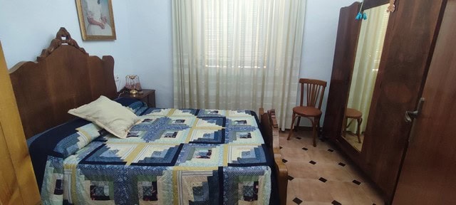 Cozy bedroom with vintage furniture and a large wooden wardrobe in a rural property in Cortes de Baz.