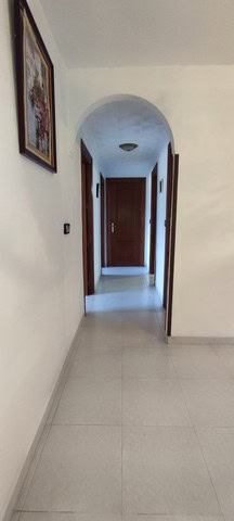 Interior view of a cozy town house hallway in Tijola, Almeria, featuring white walls, wooden doors,.