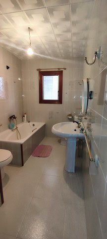 Bathroom of a town house in Tijola, Almeria, featuring a bathtub, sink, and window with natural ligh.