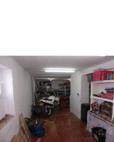 Charming village house interior in Seron, Almeria, featuring a garage with motorcycle and storage sh.