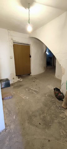 Interior view of a traditional town house in Tijola, Almeria, showing rustic walls and an arched doo.