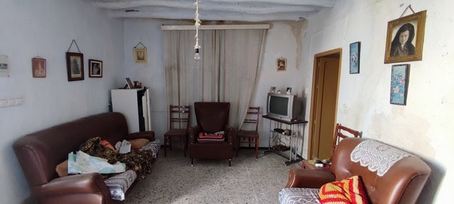 Interior view of a traditional town house living room in Tijola, Almeria, featuring vintage furnitur.