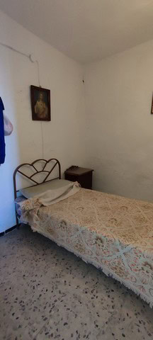 Cozy bedroom in a traditional town house in Tijola, Almeria, featuring a simple bed and classic deco.