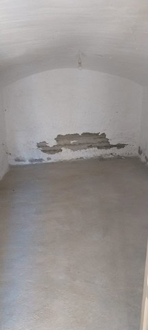 Cave house interior with damaged wall in Cantarranas, Granada.