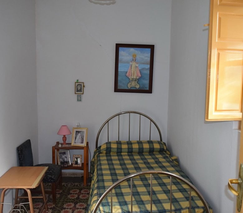 Charming bedroom in a traditional town house in Baza, Granada, featuring a cozy bed and classic deco.
