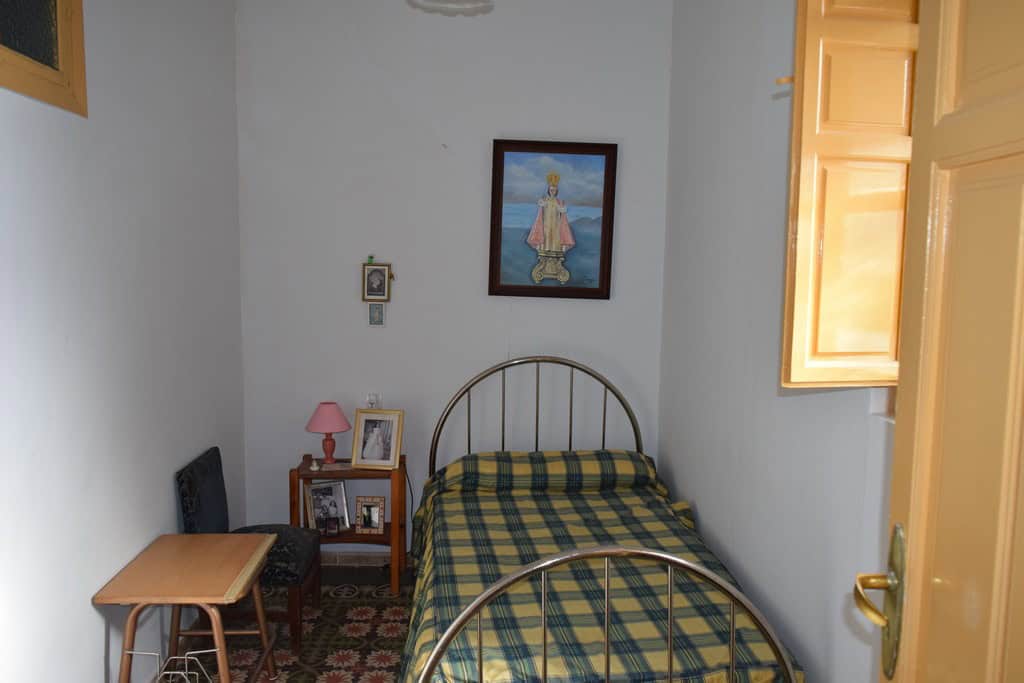 Charming bedroom in a traditional town house in Baza, Granada, featuring a cozy bed and classic deco.
