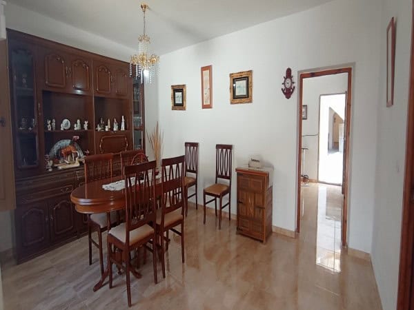 Charming dining area with wooden furniture and decorative wall art in a village property in Villanue.