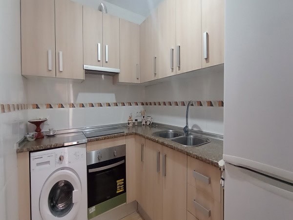 Bright kitchen with modern cabinets and appliances in Villanueva de las Torres, Granada.