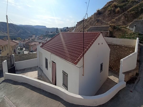 Charming village house in Villanueva de las To, Granada, with a red-tiled roof and scenic mountain v.