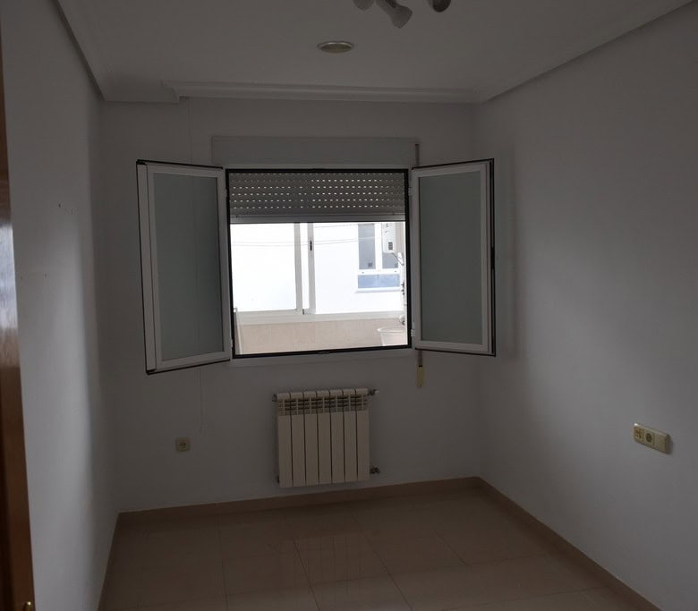 Apartment in Baza, Granada with bright interior and open window view.