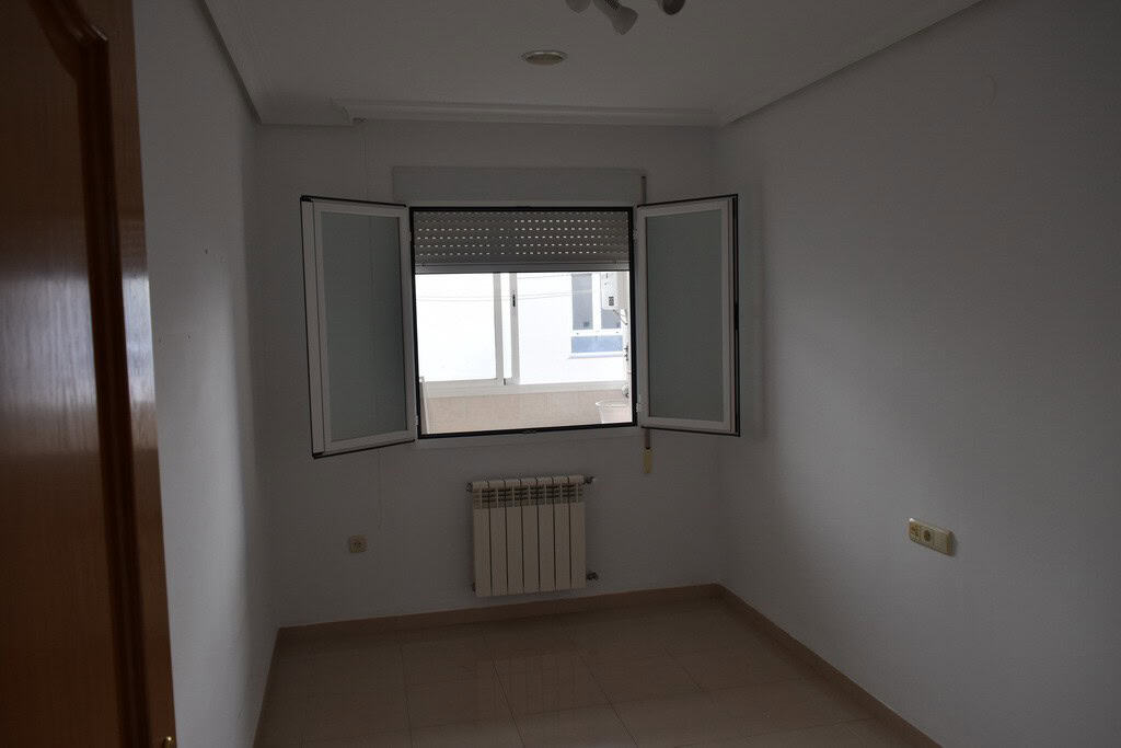Apartment in Baza, Granada with bright interior and open window view.