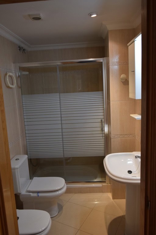 Bathroom with shower in Baza, Granada, featuring beige tiles and contemporary fixtures.