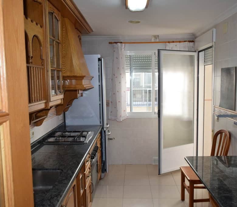 Cozy kitchen in Baza apartment, Granada with wooden cabinets and modern appliances.