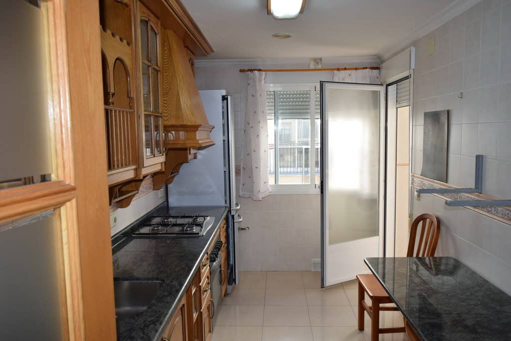 Cozy kitchen in Baza apartment, Granada with wooden cabinets and modern appliances.