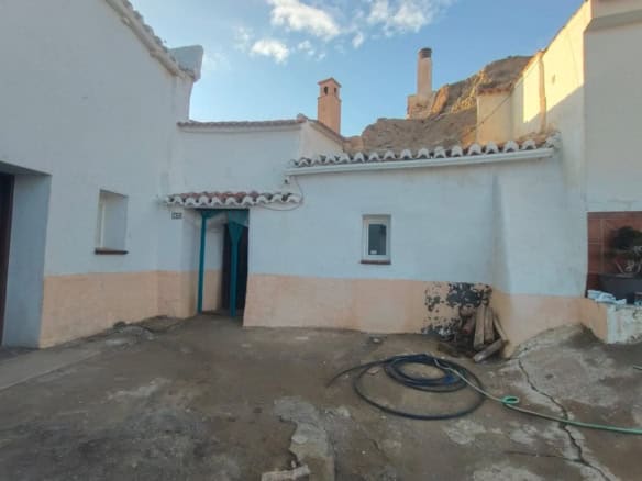 Traditional cave house in Guadix, Granada with whitewashed walls and rustic charm.