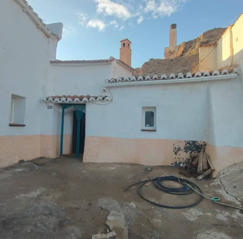 Traditional cave house in Guadix, Granada with whitewashed walls and rustic charm.