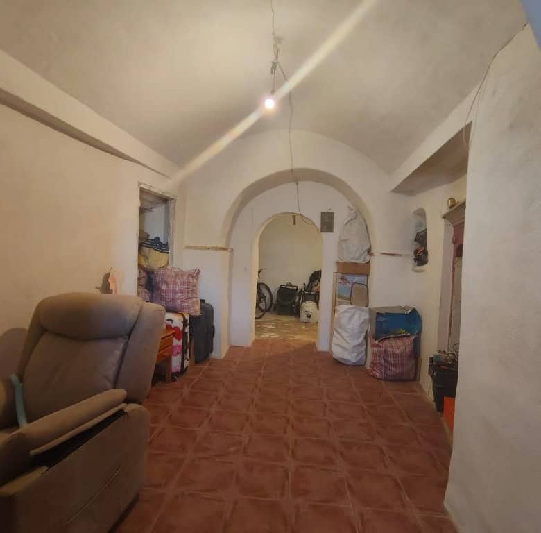 Interior view of a traditional cave house in Guadix, Granada, showcasing rustic living space and uni.