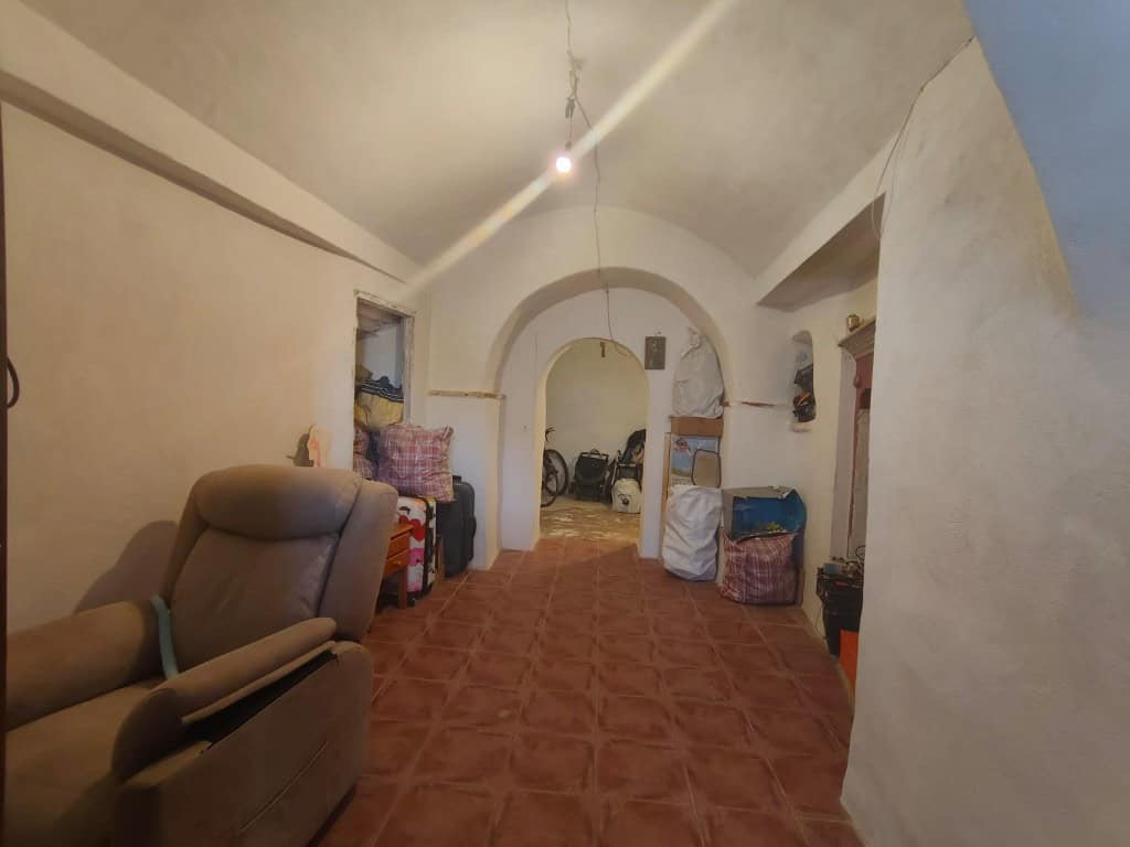 Interior view of a traditional cave house in Guadix, Granada, showcasing rustic living space and uni.