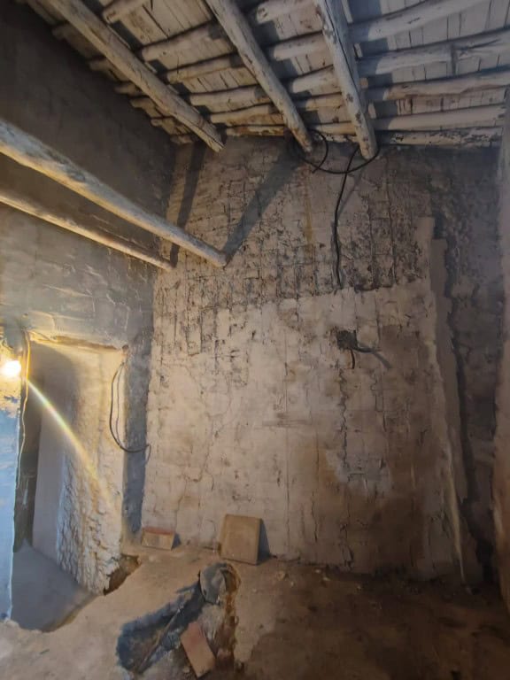 Interior view of a rustic cave house in Guadix, Granada, showing unfinished walls and ceiling constr.