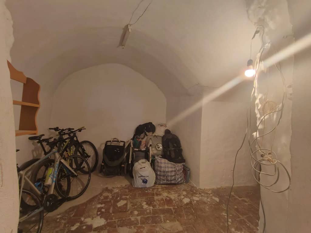 Cave house interior with bicycles and luggage in Guadix, Granada. Unique underground living space wi.