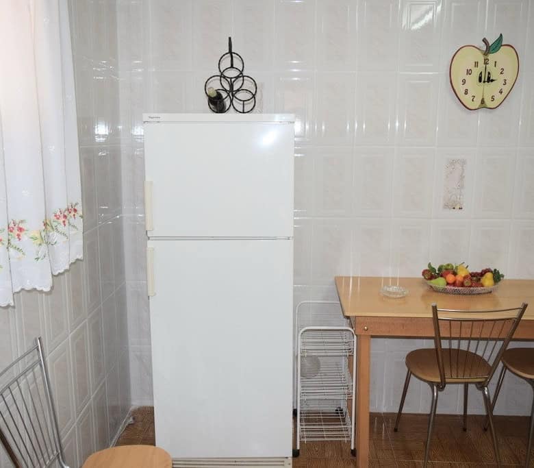 Charming rural kitchen with a white refrigerator, wooden dining table, and chairs in Pozo Alcon, Jae.