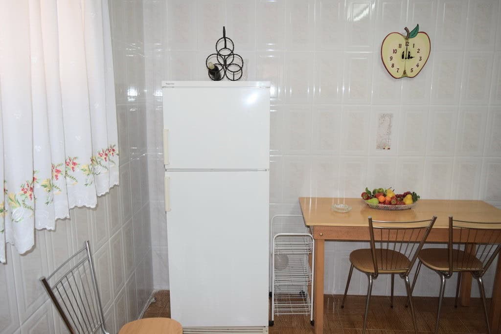 Charming rural kitchen with a white refrigerator, wooden dining table, and chairs in Pozo Alcon, Jae.