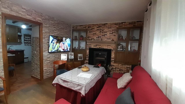 Interior view of a cozy living room with brick walls and a red sofa in Bayarque, Almeria.